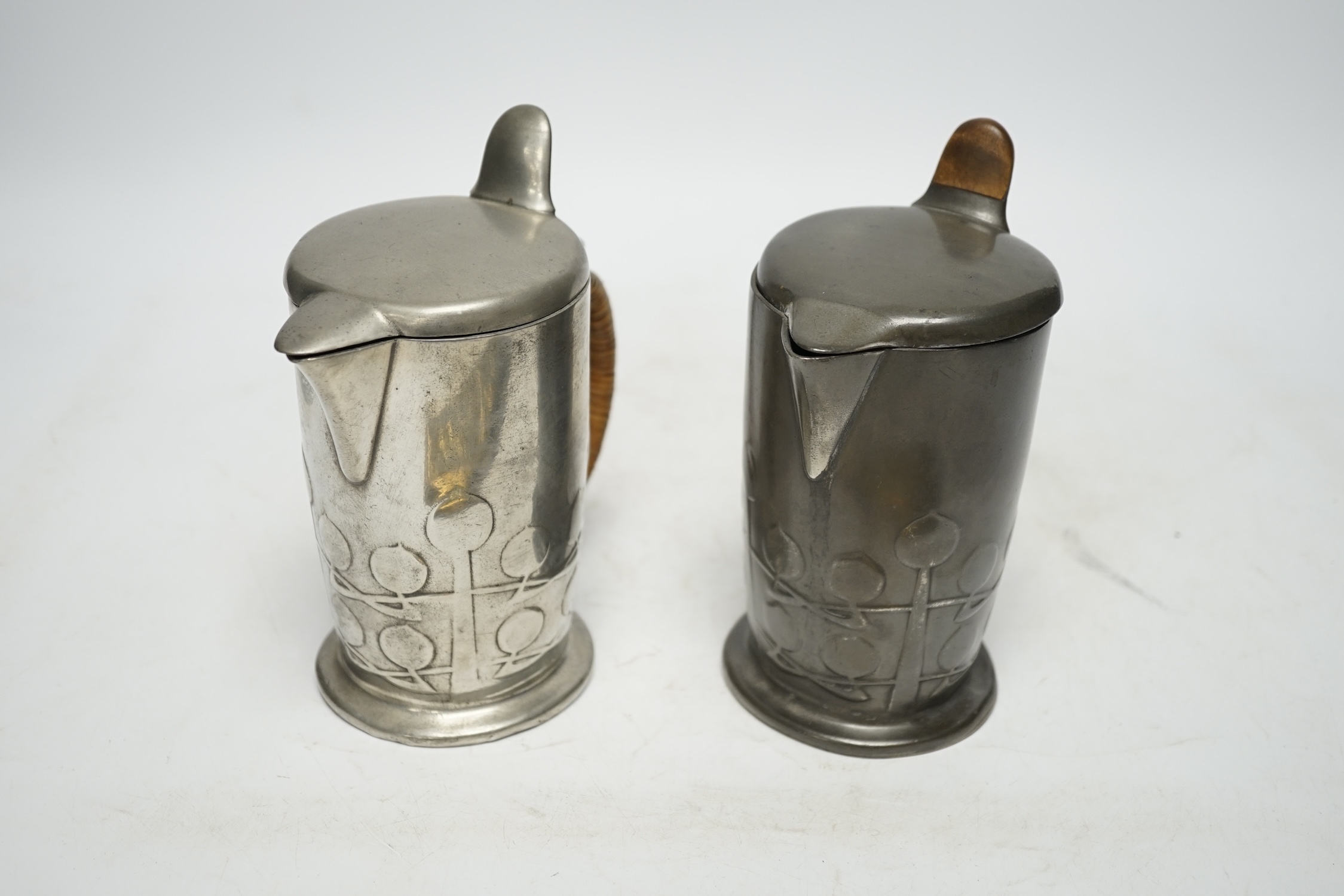 Archibald Knox (1864-1933) for Liberty & Co, two Tudric hot water jugs and an Art Nouveau brass pen tray, tray 24cm long (3). Condition - fair to good